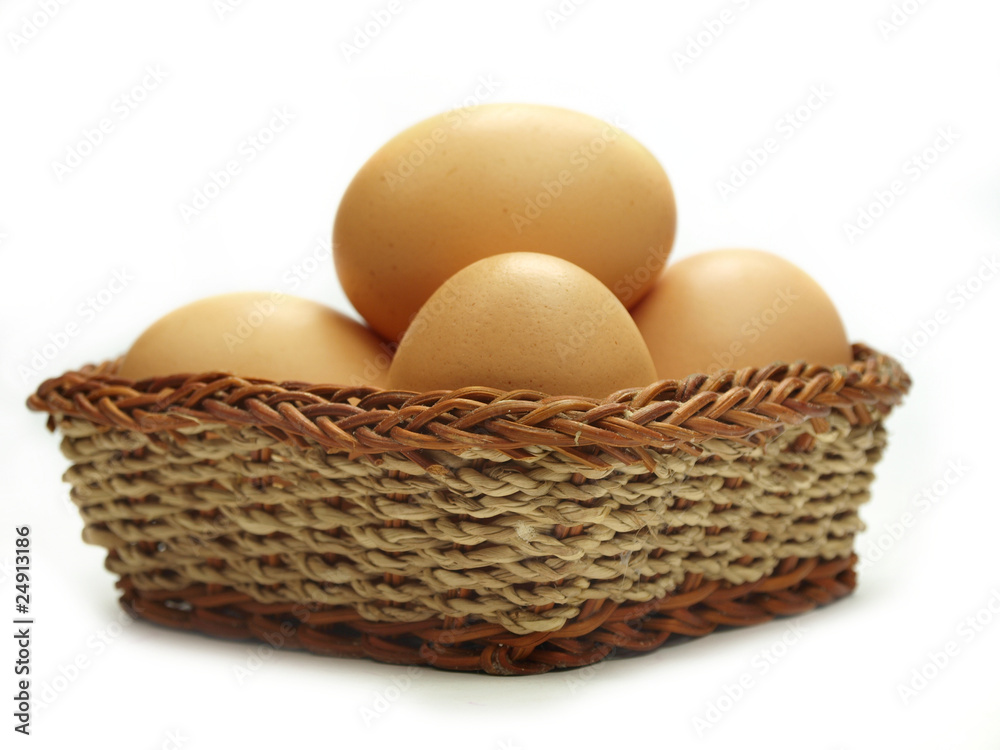 Eggs in a small basket isolated on white background Eggs in a small basket isolated on white background
