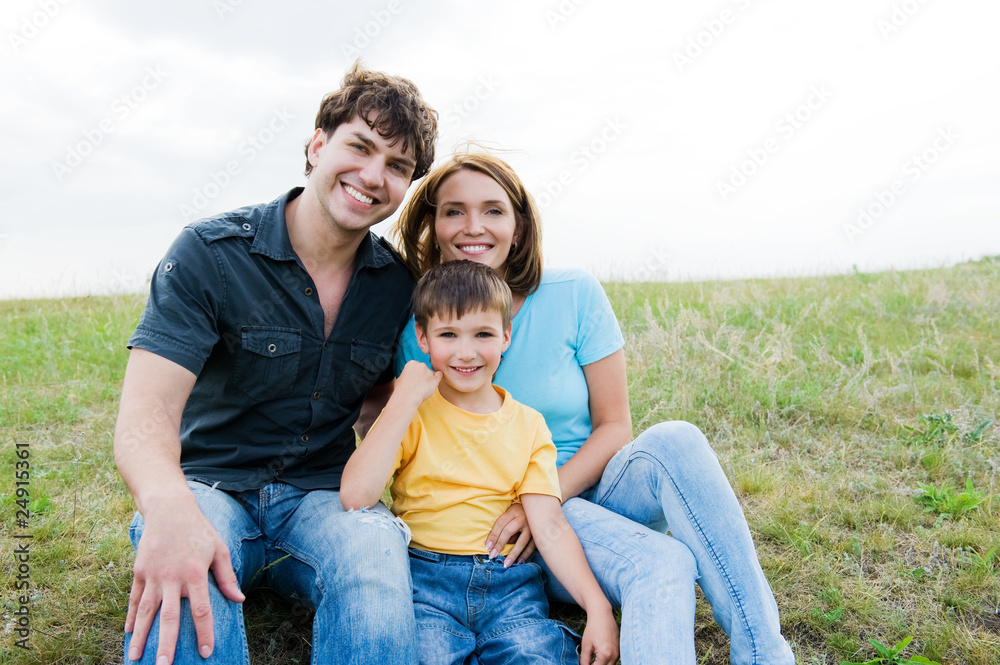 Happy beautiful young family posing outdoors Happy beautiful young family posing outdoors