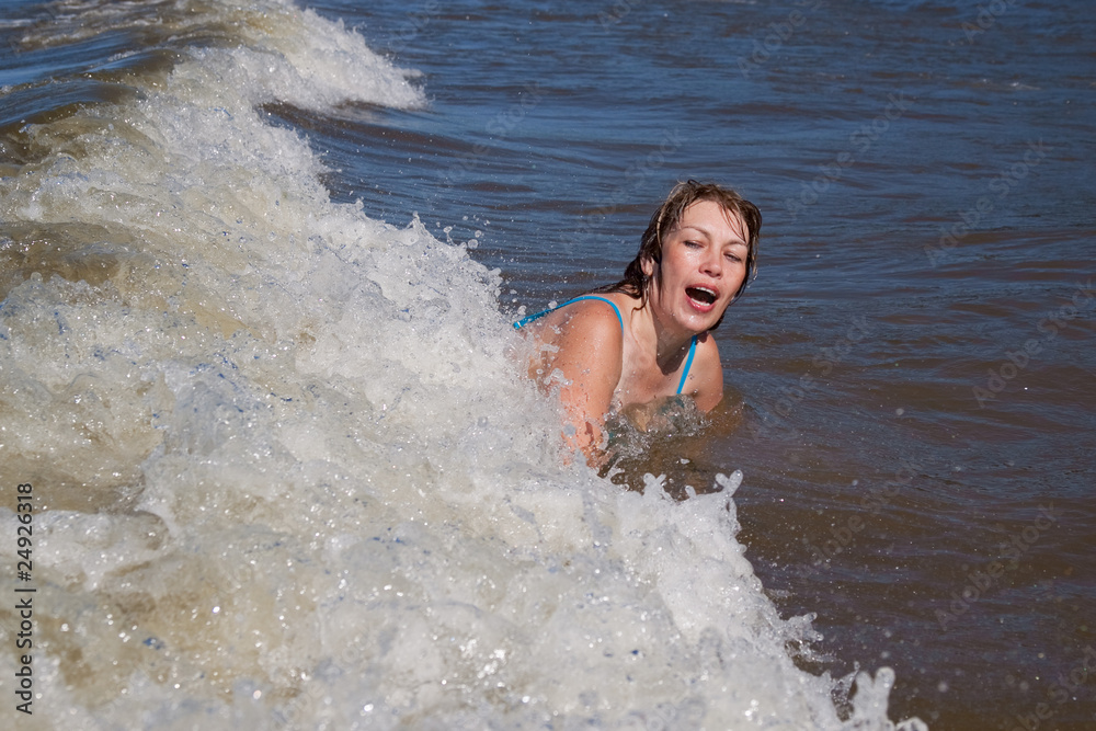 Fototapeta premium woman in sea splashed by wave