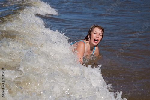 woman in sea splashed by wave