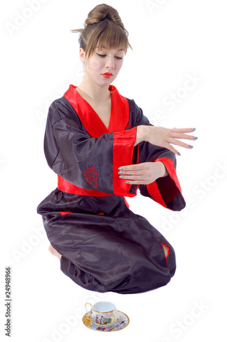Beautiful sitting girl in japan clothes with tea cup