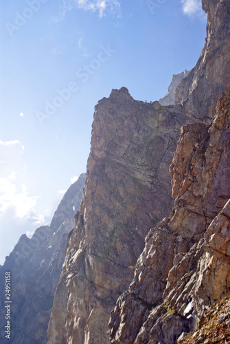 two men stand on the top of large rock