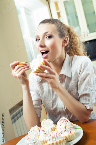 Young happy woman with plate of cakes at home
