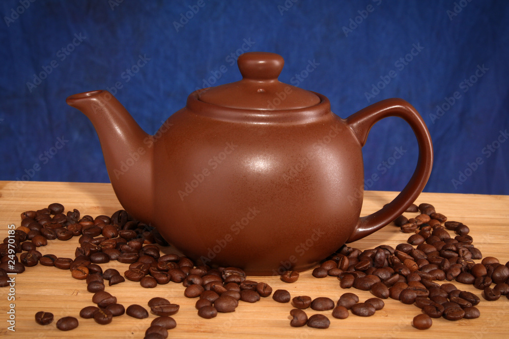 teapot with coffee grain on blue background