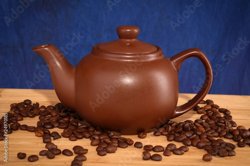 teapot with coffee grain on blue background