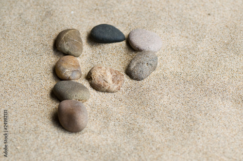 lettre P en galets zen dans le sable