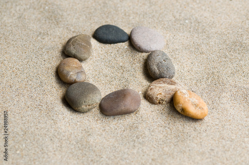 lettre Q en galets zen dans le sable