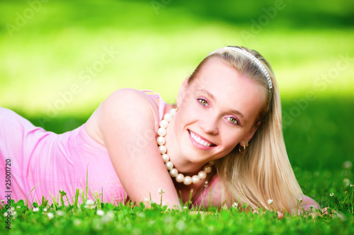 Beautiful blonde lying on the grass