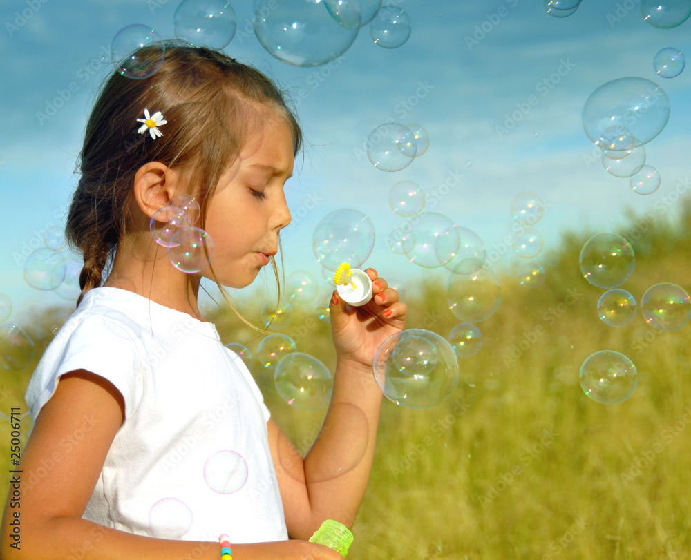 Sumer wishes, little girl blowing soap bubbles at sunset Sumer wishes, little girl blowing soap bubbles at sunset