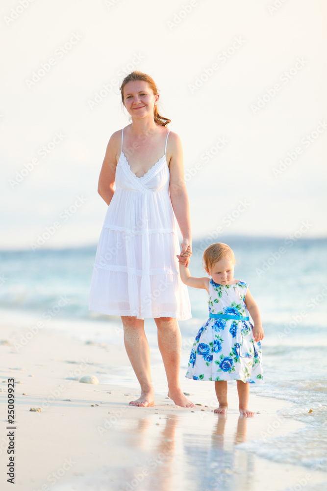 Mother and daughter on tropical beach at sunset Mother and daughter on tropical beach at sunset