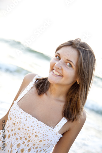 Pretty young woman standing on beach