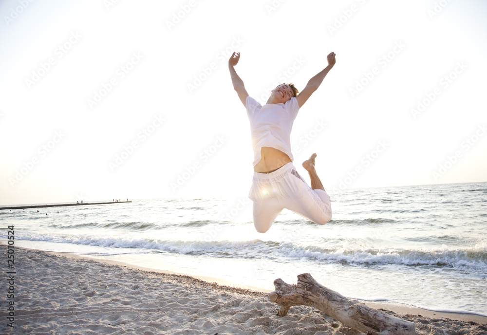 Young men jumping on the beach at dawn Young men jumping on the beach at dawn
