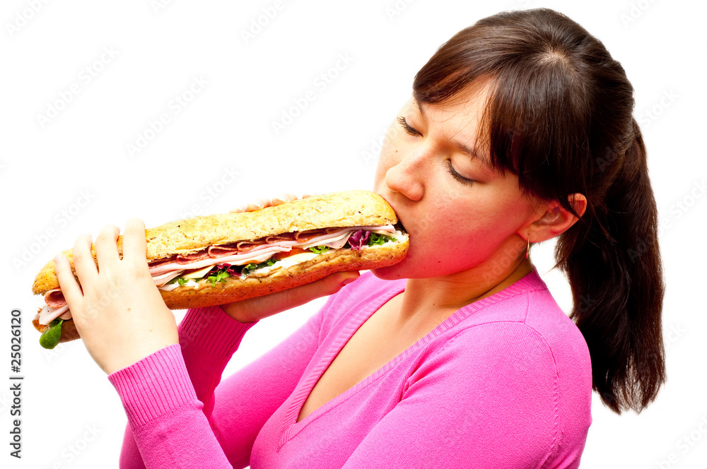young woman eating a freshly made sub sandwich young woman eating a freshly made sub sandwich
