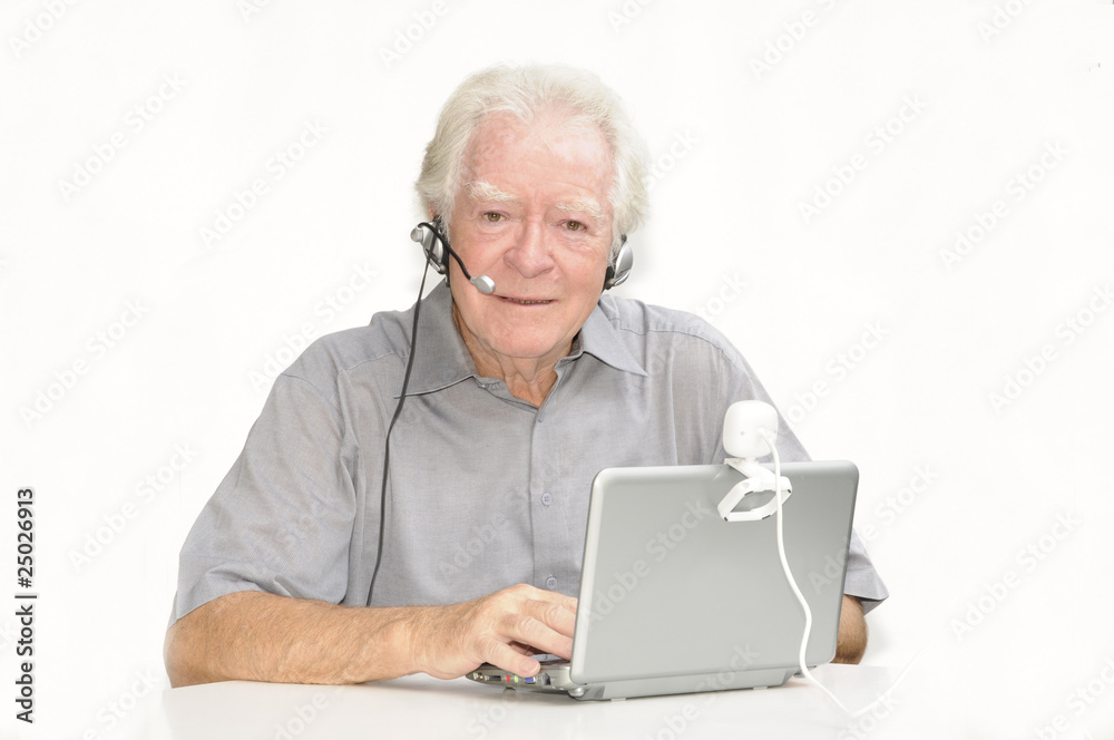 Älterer Herr mit Netbook, Webcam und Headset Älterer Herr mit Netbook, Webcam und Headset