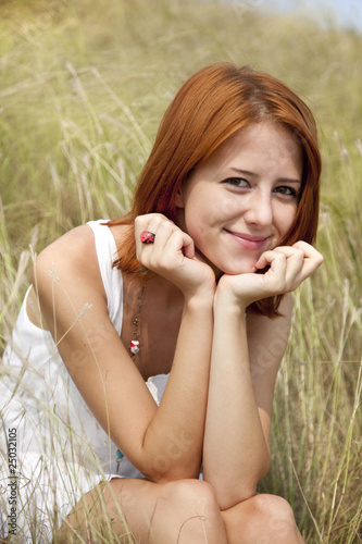 Beautiful red-haired girl at grass