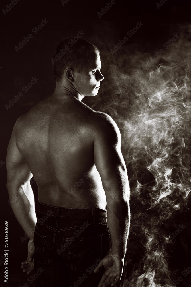 Naklejka premium young sporty man over Smoke.