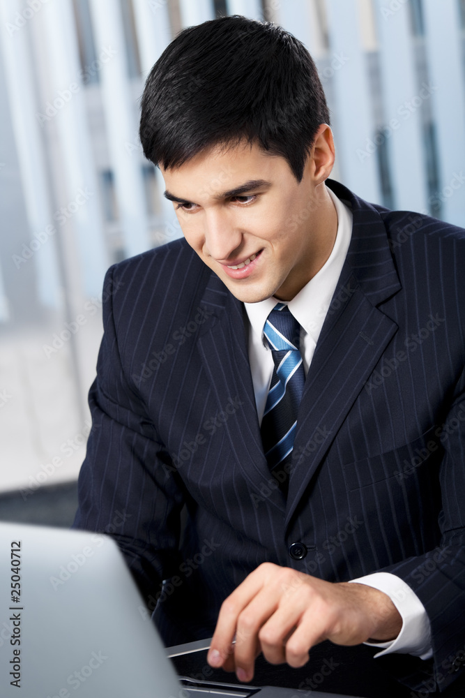 Successful businessman with laptop at office Successful businessman with laptop at office