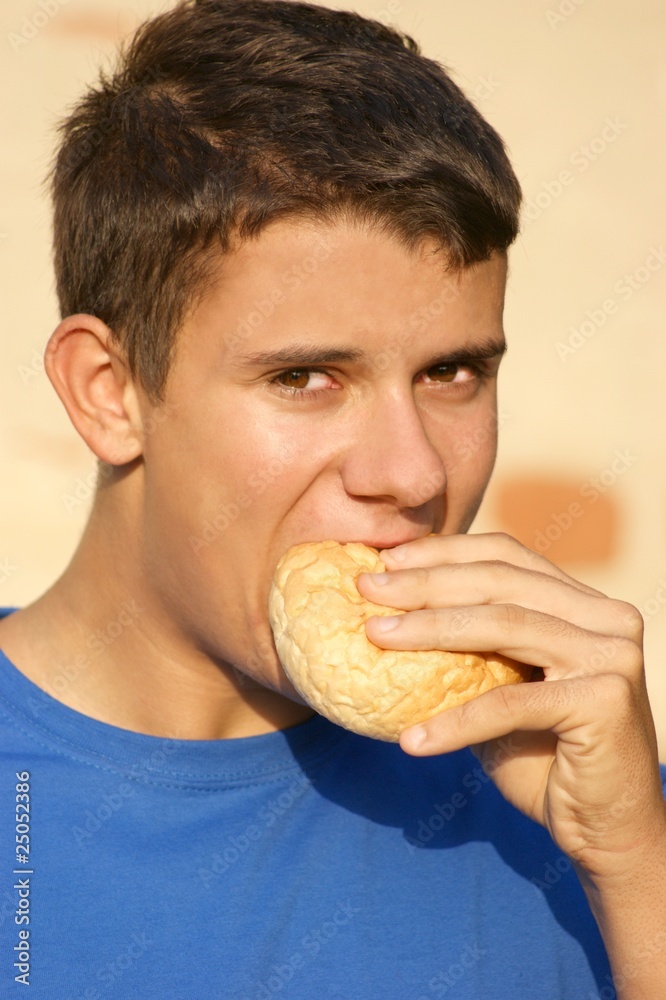 ein jugendlicher isst ein trockenes Brötchen ein jugendlicher isst ein trockenes Brötchen