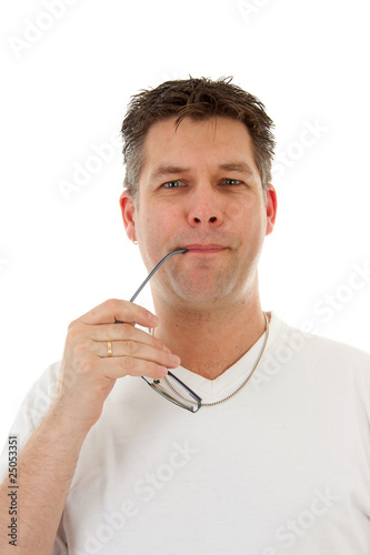 man is holding glasses in mouth over white background