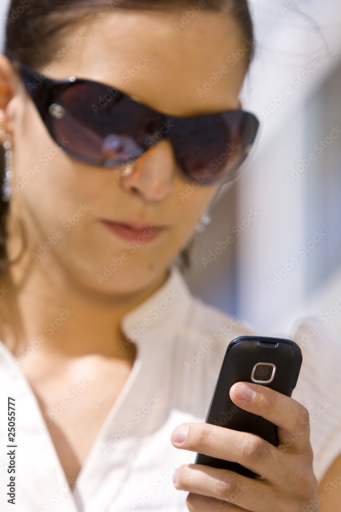 Female (unsharp) checking her mobile phone (sharp) Female (unsharp) checking her mobile phone (sharp)