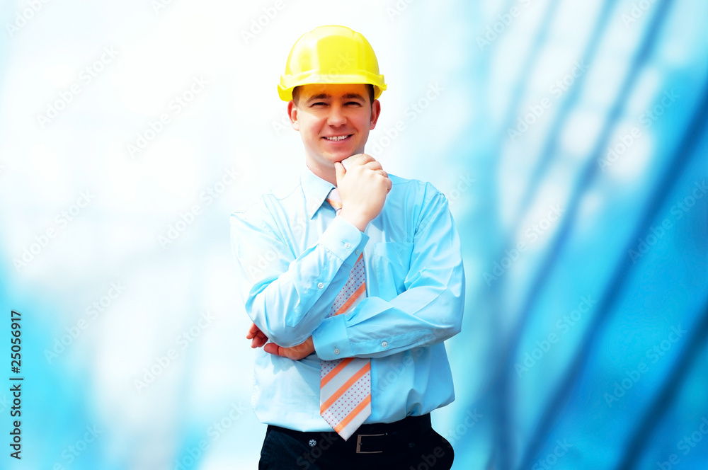 Young architect wearing a protective helmet standing on the buil Young architect wearing a protective helmet standing on the buil