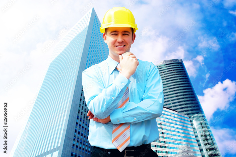 Young architect wearing a protective helmet standing on the buil Young architect wearing a protective helmet standing on the buil