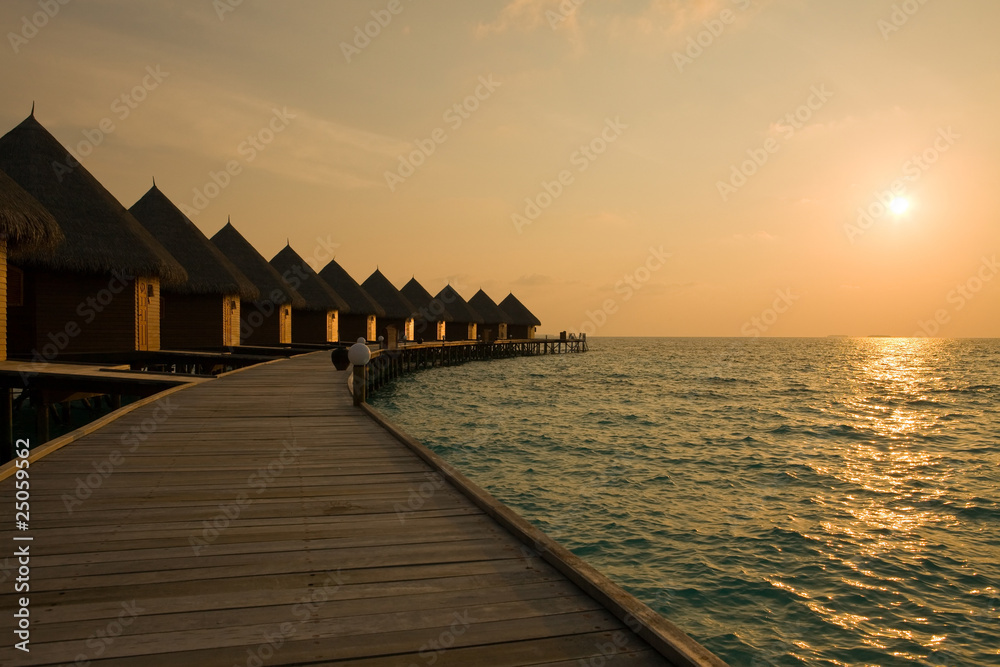Obraz premium Maldives.Villa on piles on water at the time sunset...