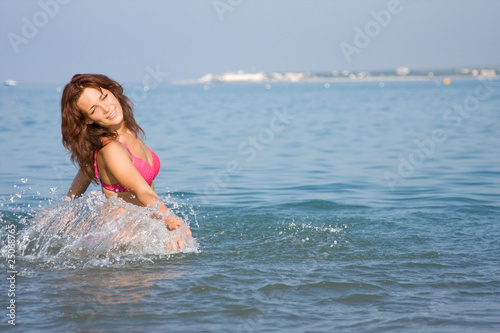 Young girl is splashing in the sea