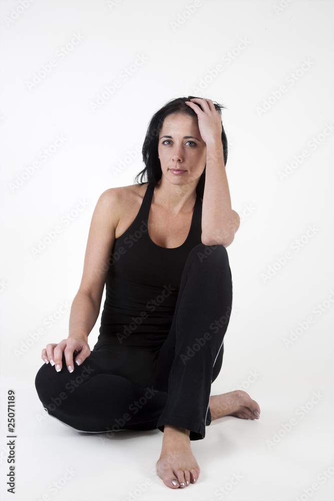 Woman in exercise clothes, sitting on the floor Woman in exercise clothes, sitting on the floor
