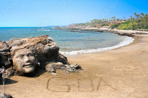 Stone face on  beautiful tropical beach in Goa photo