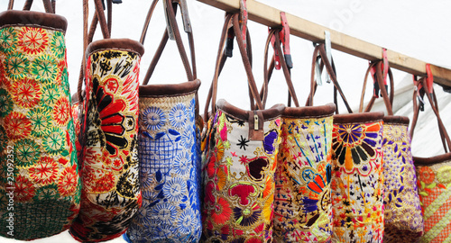 Colourful embroidered bags hanging in a market stall, Amsterdam © annavee