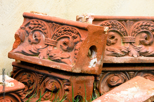 Antique molded bricks stacked on grass.