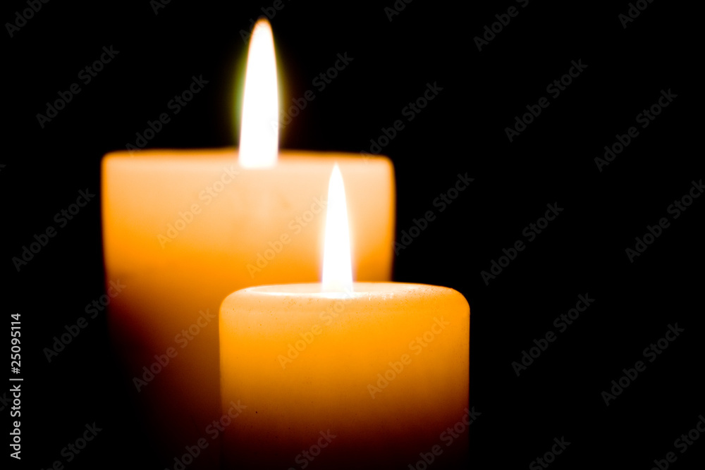 Close up of two lit white candles on black background. Close up of two lit white candles on black background.