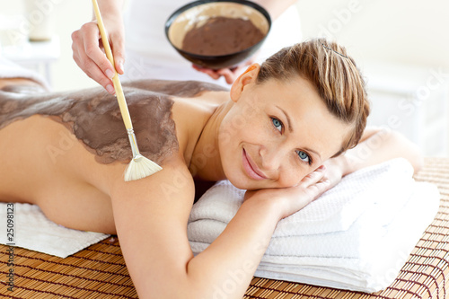 Pretty young woman enjoying a beauty treatment with mud