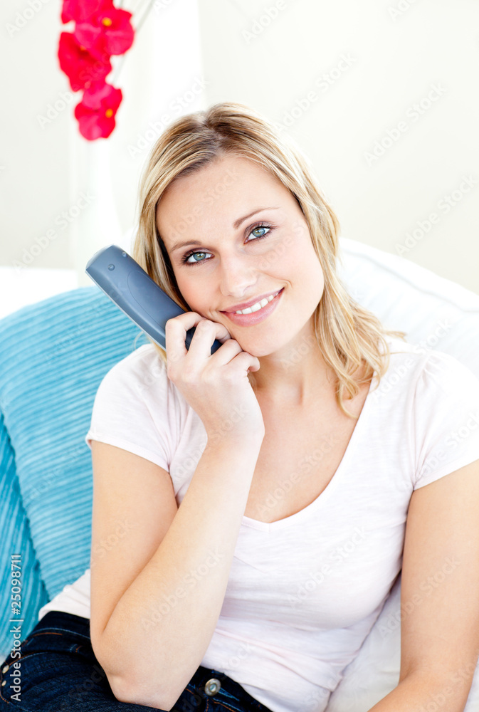 Captivating woman smiling at the camera holding a remote Captivating woman smiling at the camera holding a remote