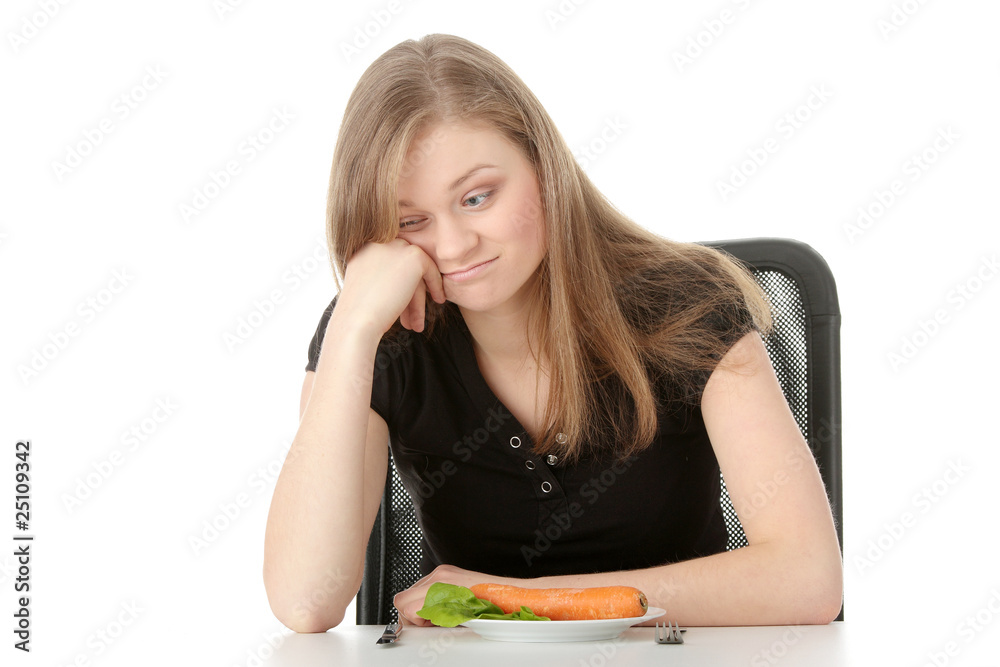 Young woman eating carrot from plate - sad Young woman eating carrot from plate - sad