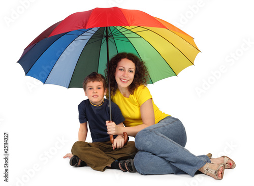 mother and son with big multicolored umbrella sitting isolated