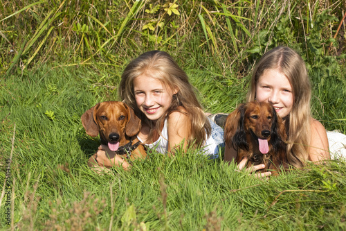 little blonde girl and a loving puppy dachshund photo