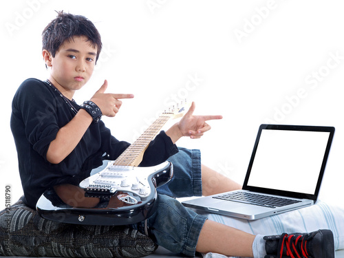 child with guitar pointing at computer display