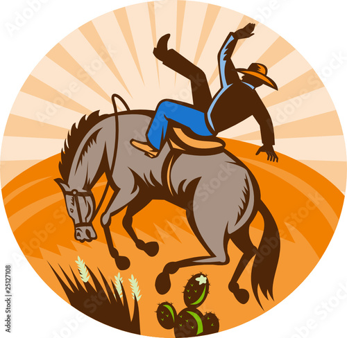 Rodeo cowboy falling off horse in desert