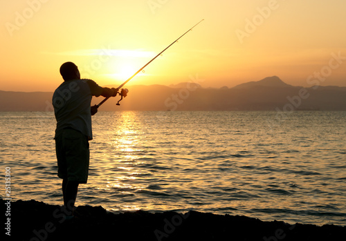 Man fishing in last rays of sunlight