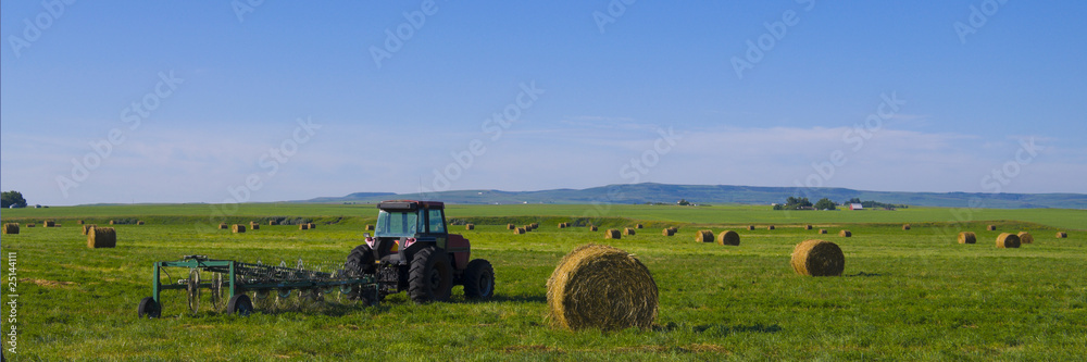 Tractor with rototiller attached in a hay field Tractor with rototiller attached in a hay field
