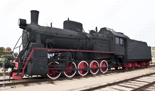 Steam locomotive beside a railway station platform.