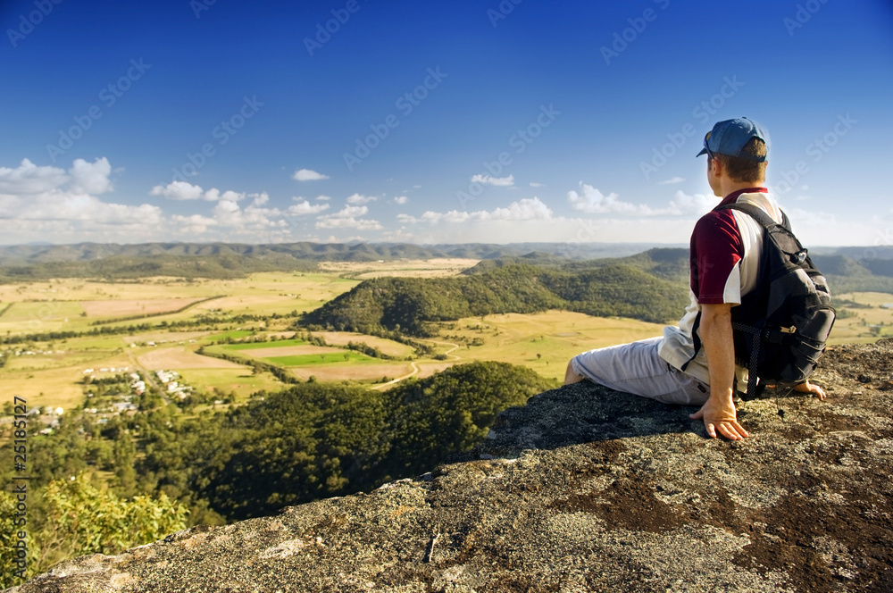 Hiker sitting on ledge at Giants Leap in Sandy Hollow, New South Wales, Australia