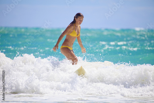 Photography teenage girl in a yellow bikini surfing in Hawaii