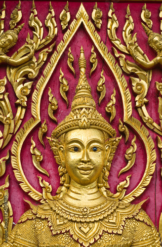 Buddha carved gold paint on church door © wuttichok