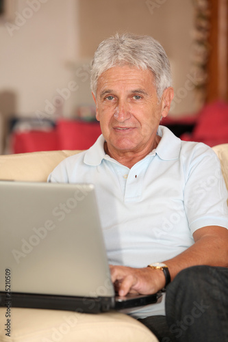 Closeup of senior man with laptop computer at home