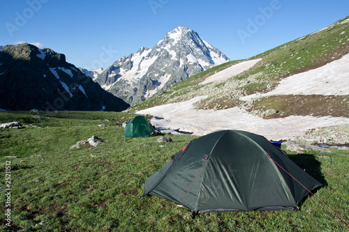 Camping tents on sunny grassland.