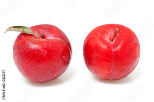 two red plums over white background