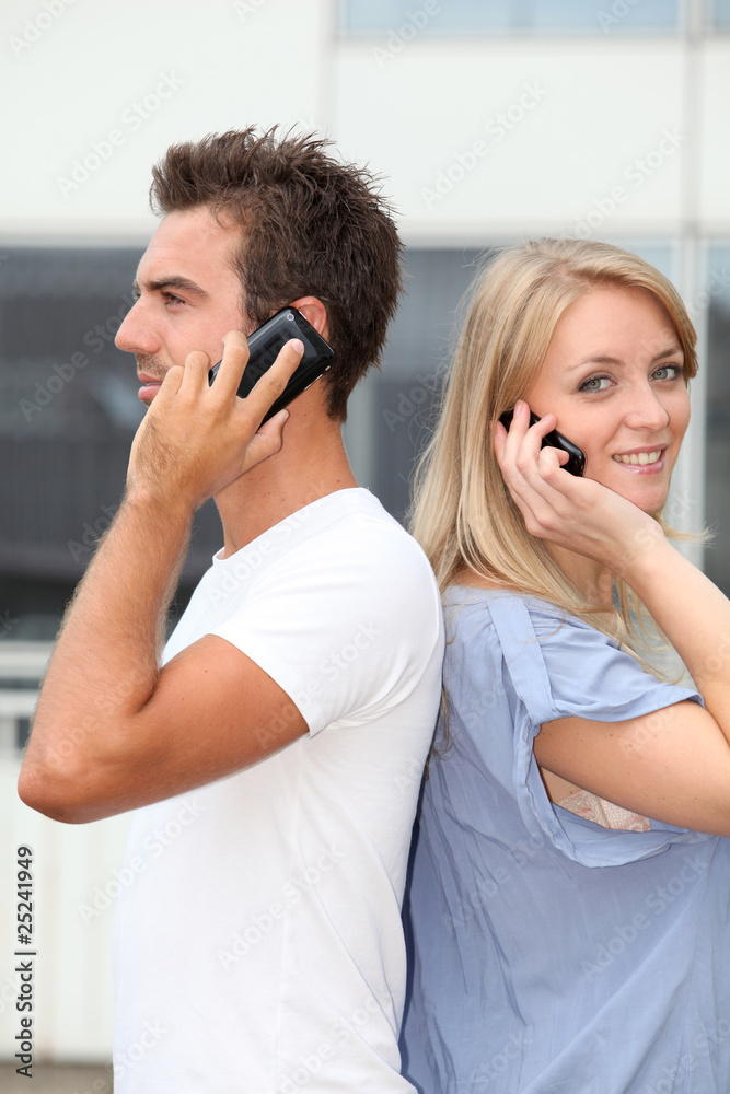 Couple standing outside with mobile phone Couple standing outside with mobile phone